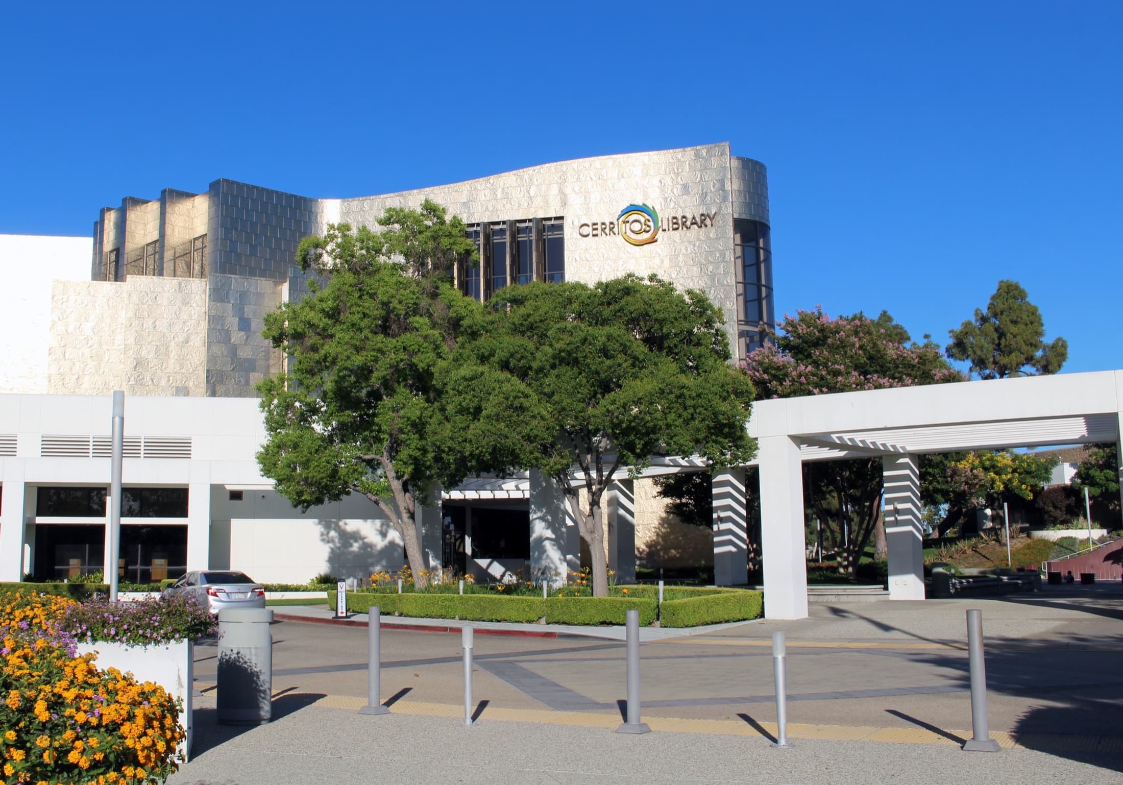 Exterior of the Cerritos Library titanium and glass building under a clear sky