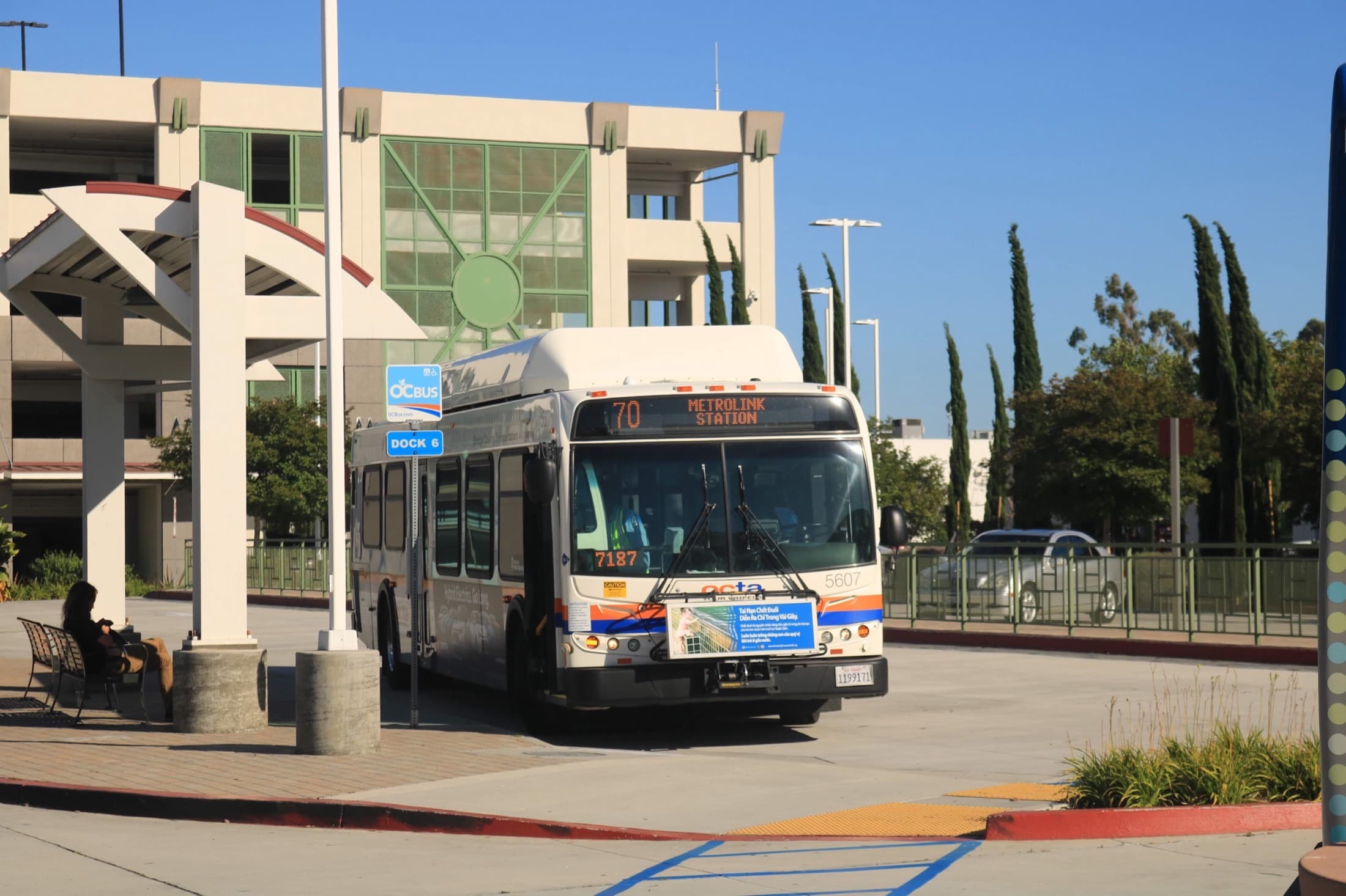 OCTA bus at a Tustin transit center dock under clear sky