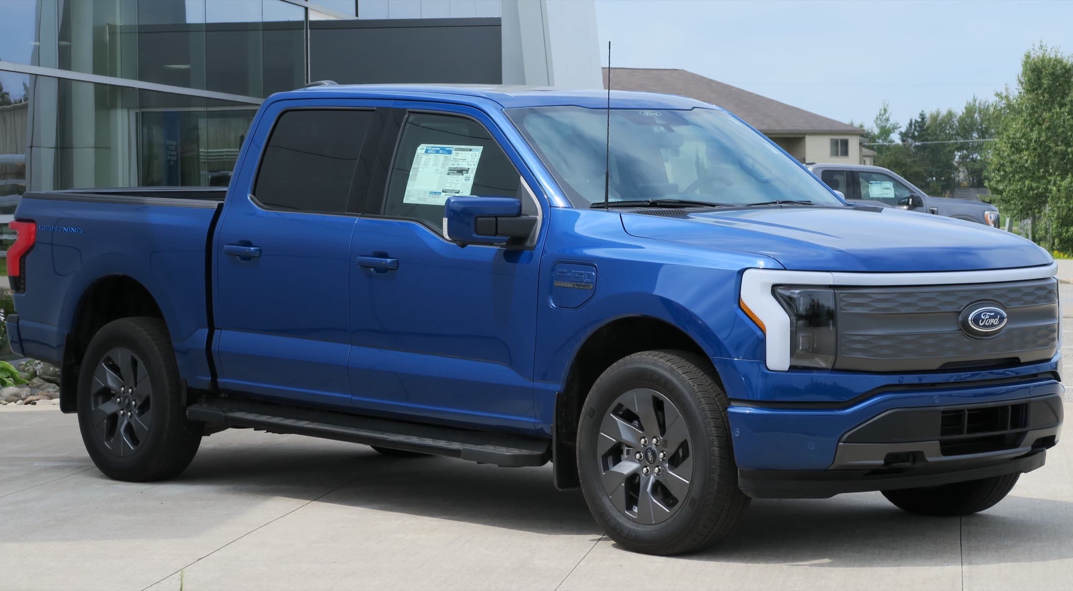 Blue 2022 Ford F-150 Lightning Lariat parked outdoors, front three-quarter view