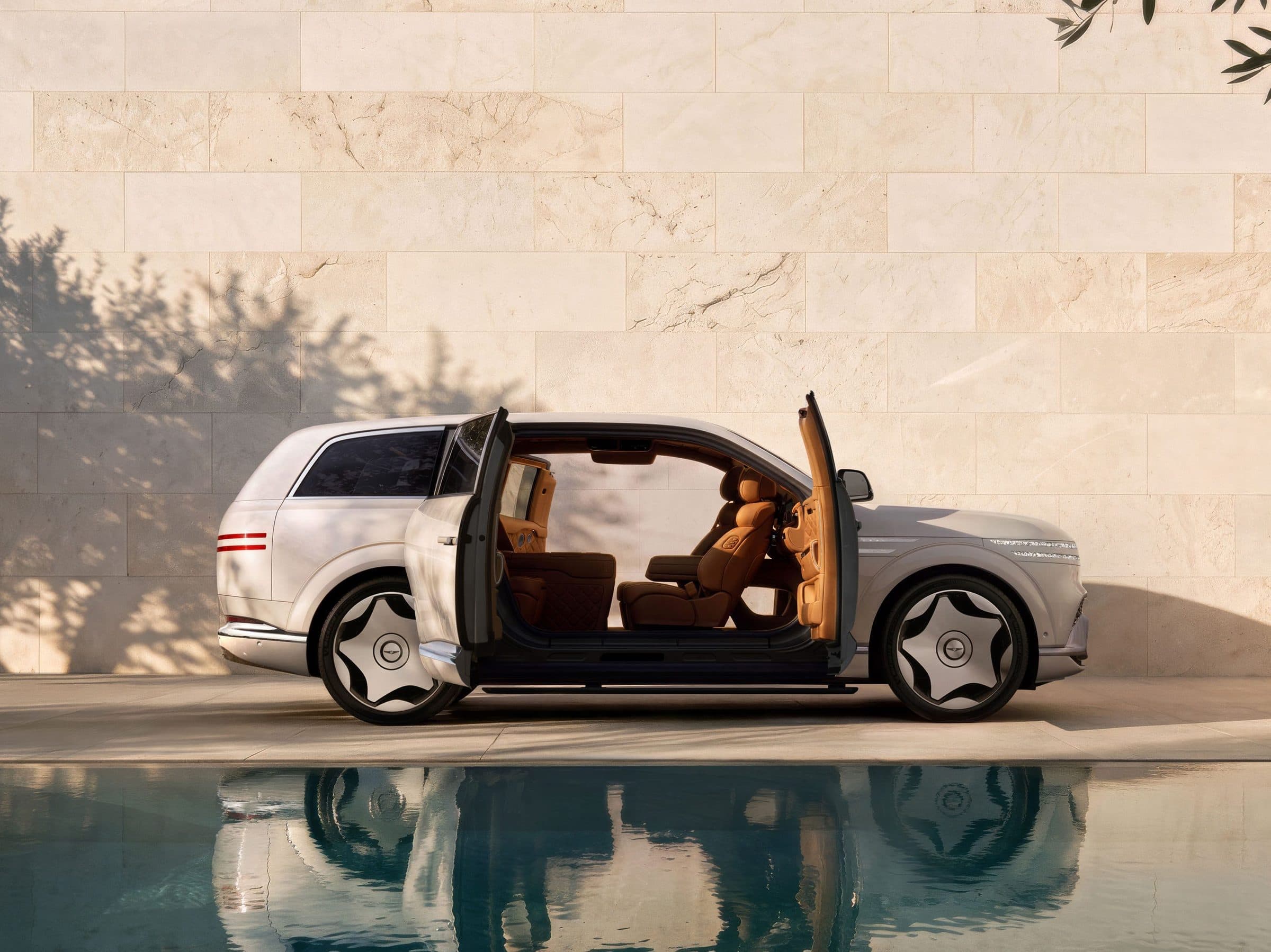 Pearl-white Genesis GV90 Neolun with front and rear coach doors open beside a reflecting pool, showing the pillarless cabin opening