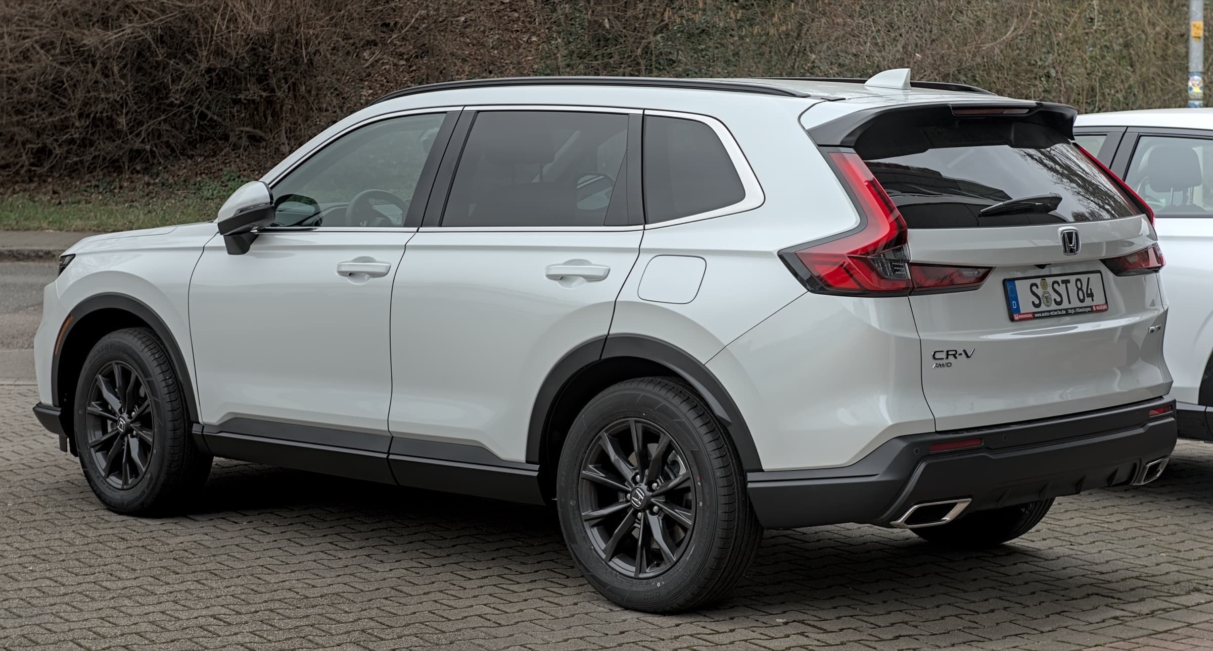 White Honda CR-V Hybrid, rear three-quarter view on a paved lot