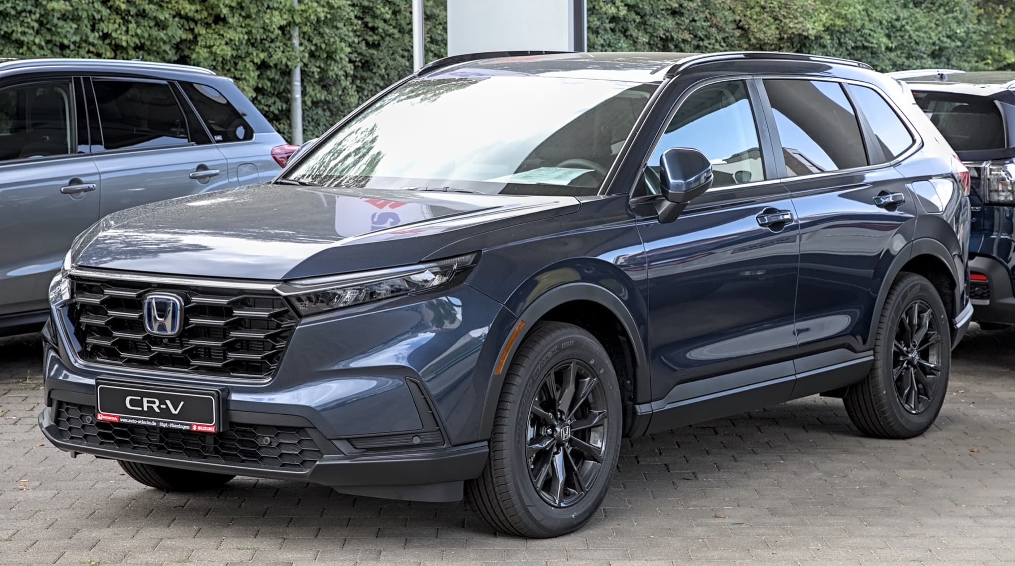 Sixth-generation Honda CR-V Hybrid parked outdoors in three-quarter view