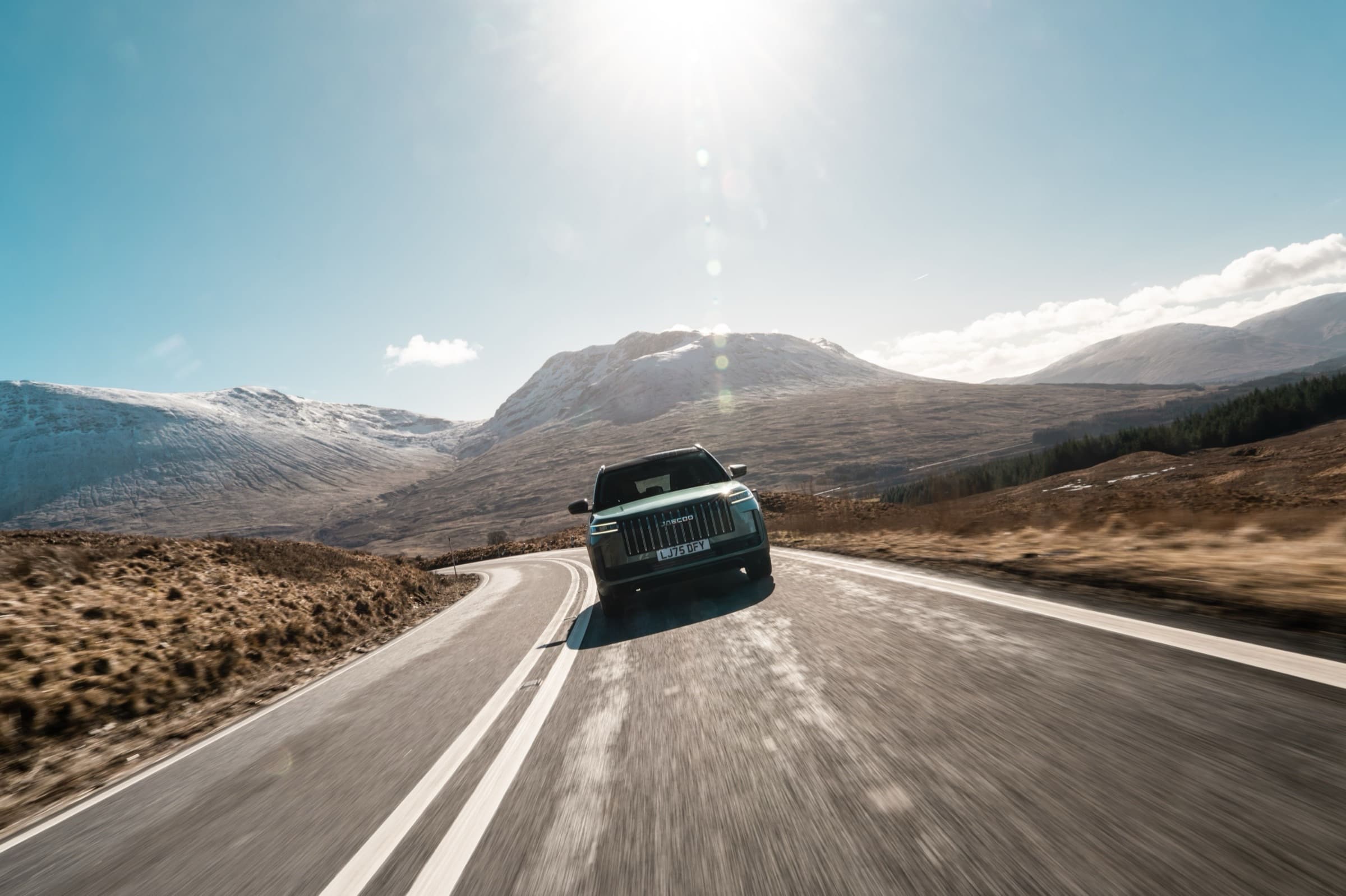 Dark green Jaecoo SUV on a mountain road in the UK with a British license plate