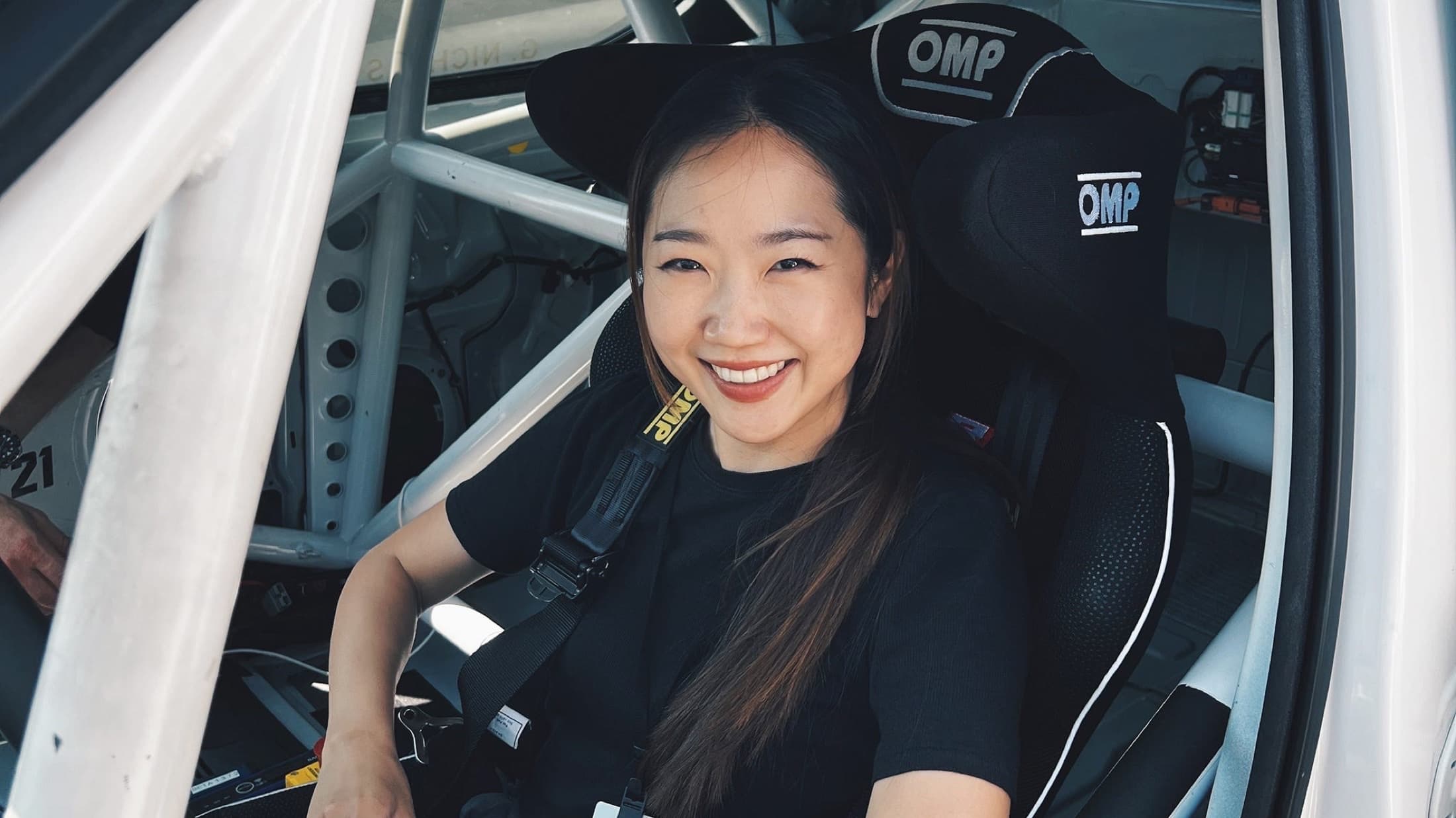 Julliana Cho smiling from a racing seat inside a roll-caged car