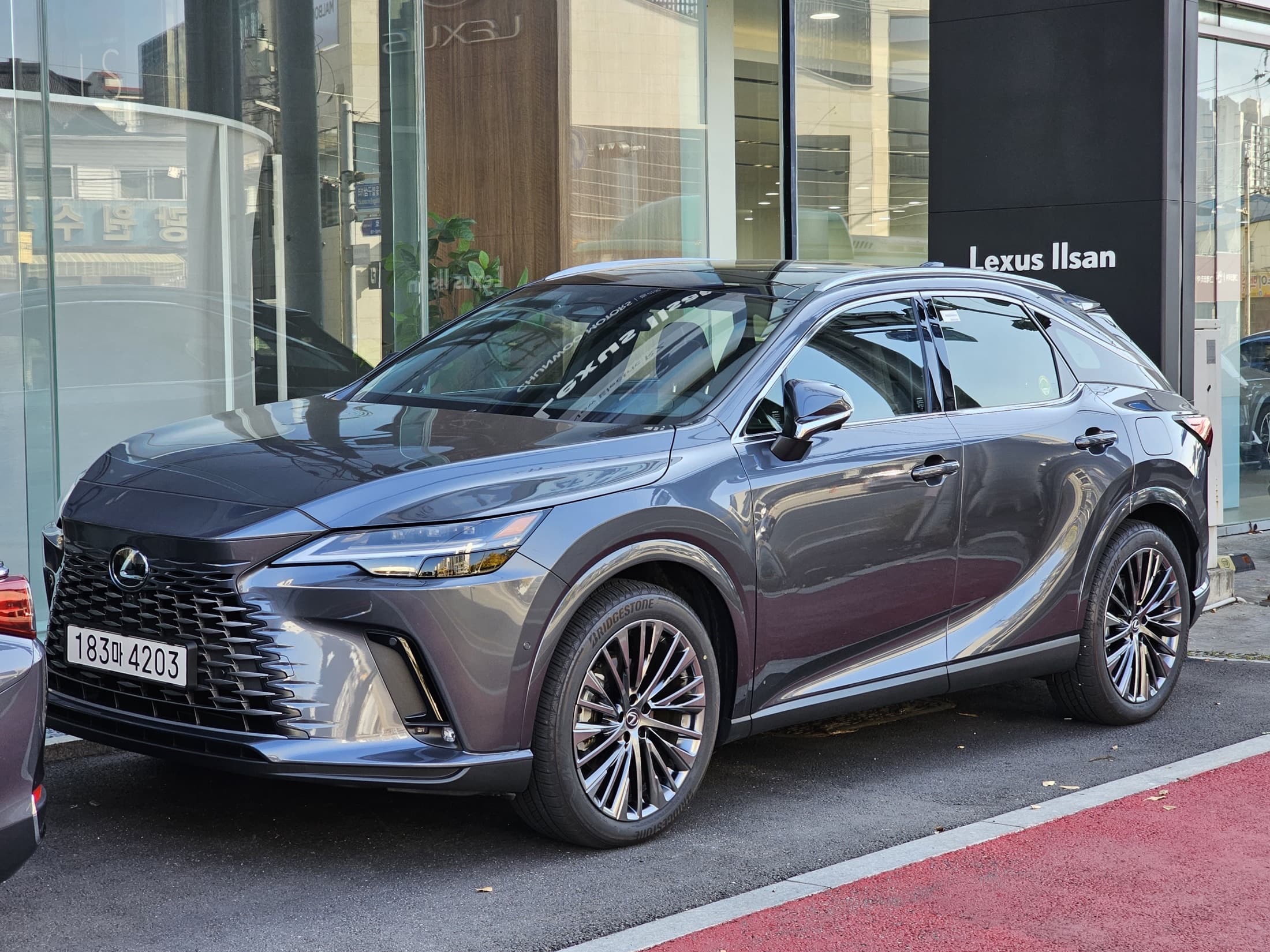 Lexus RX 350h AWD in Sonic Chrome, front three-quarter view at a dealership