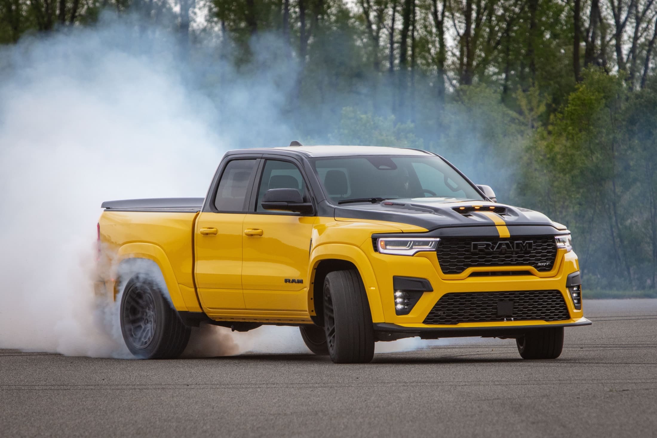 Yellow and black 2027 Ram 1500 Rumble Bee SRT doing a burnout with tire smoke