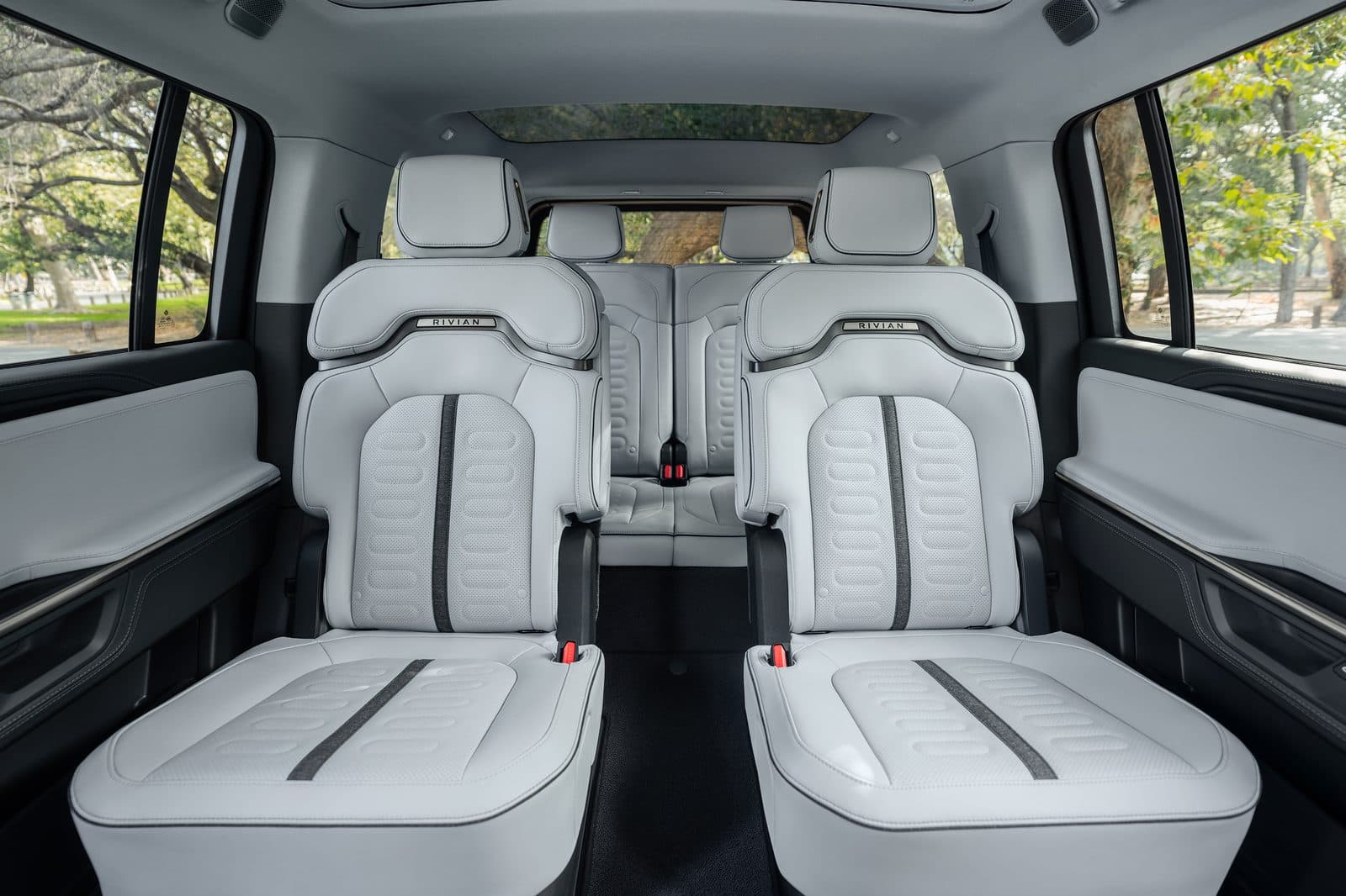 2027 Rivian R1S second-row captain’s chairs in a light interior with center pass-through