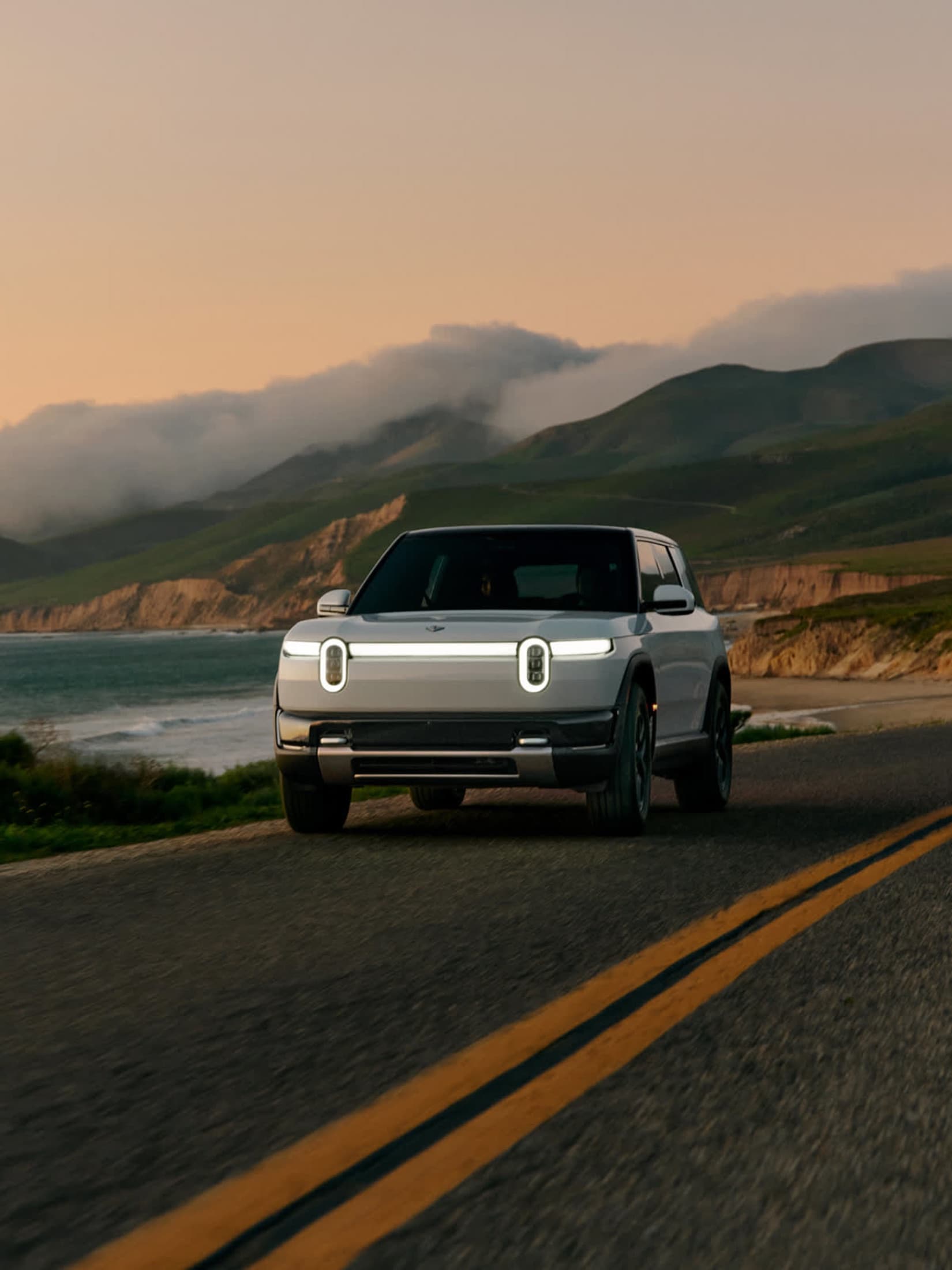Rivian R2 electric SUV on an open road in three-quarter front view