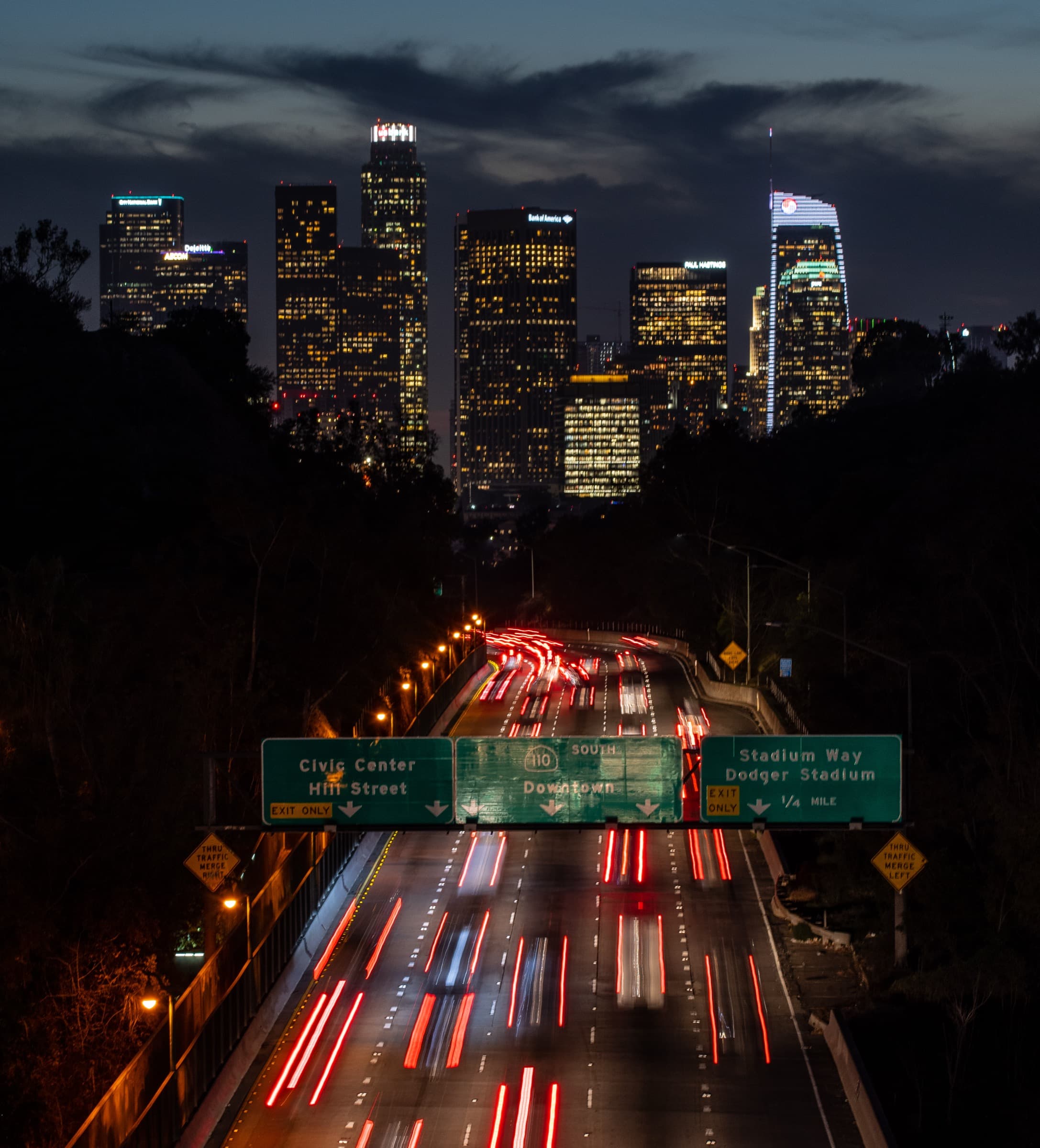 Downtown Los Angeles skyline above traffic on the 110 Freeway at night