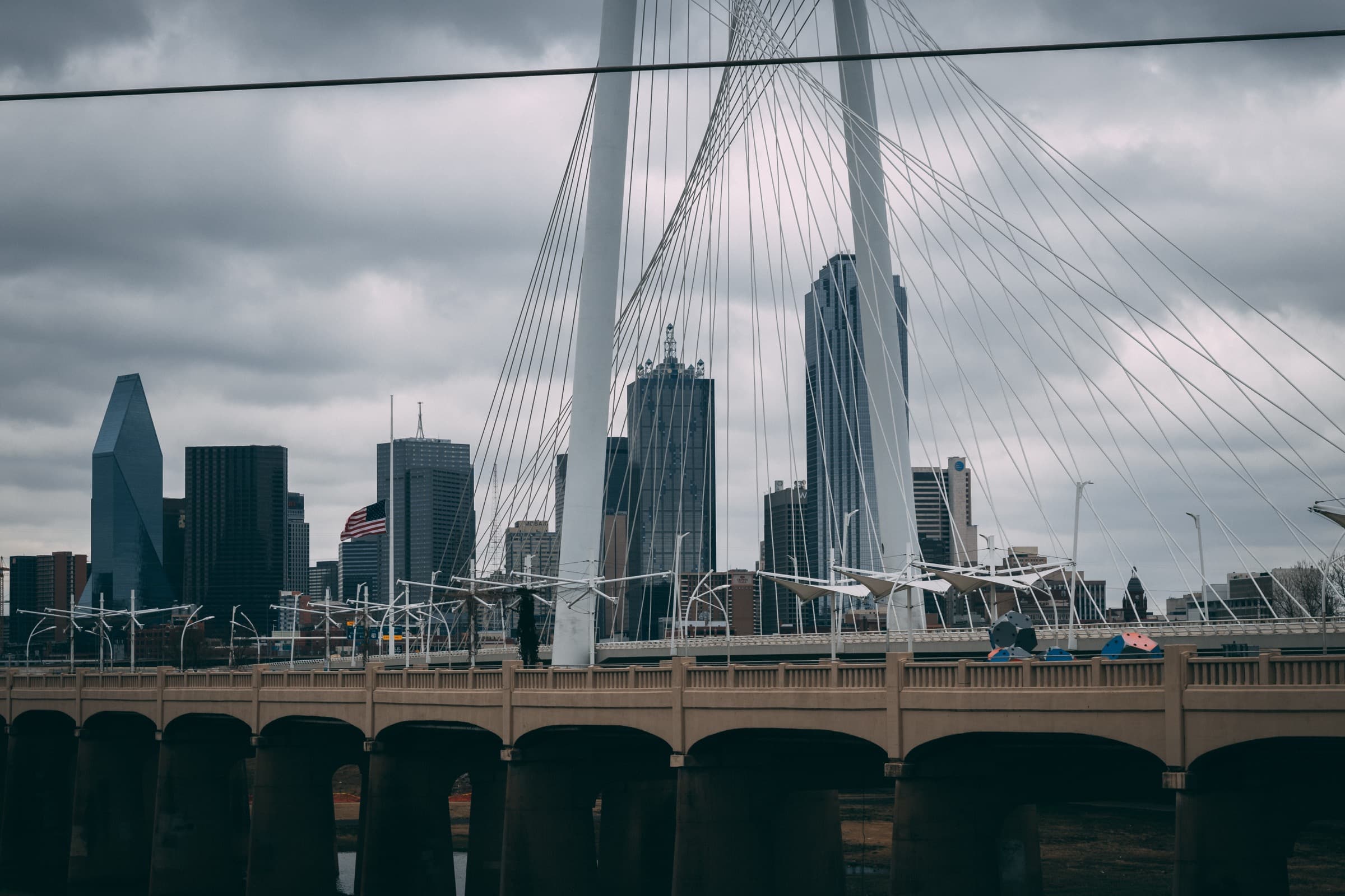 Dallas skyline beyond a roadway and bridge in North Texas